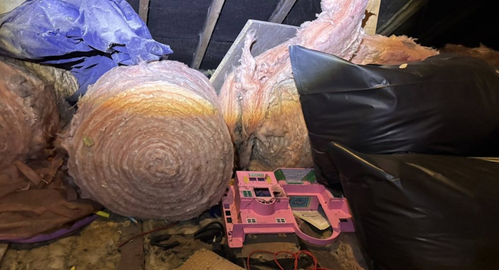 Piles of loft insulation and unwanted items from a loft clearance